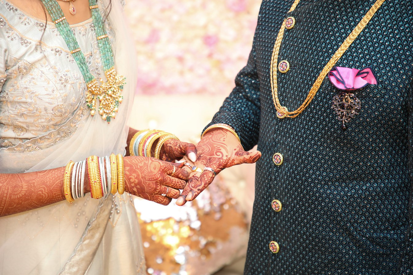 Crop Indian newlyweds in traditional wear